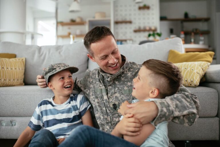 military dad playing with children on the floor